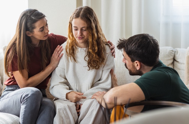 Photo of family consoling teenager