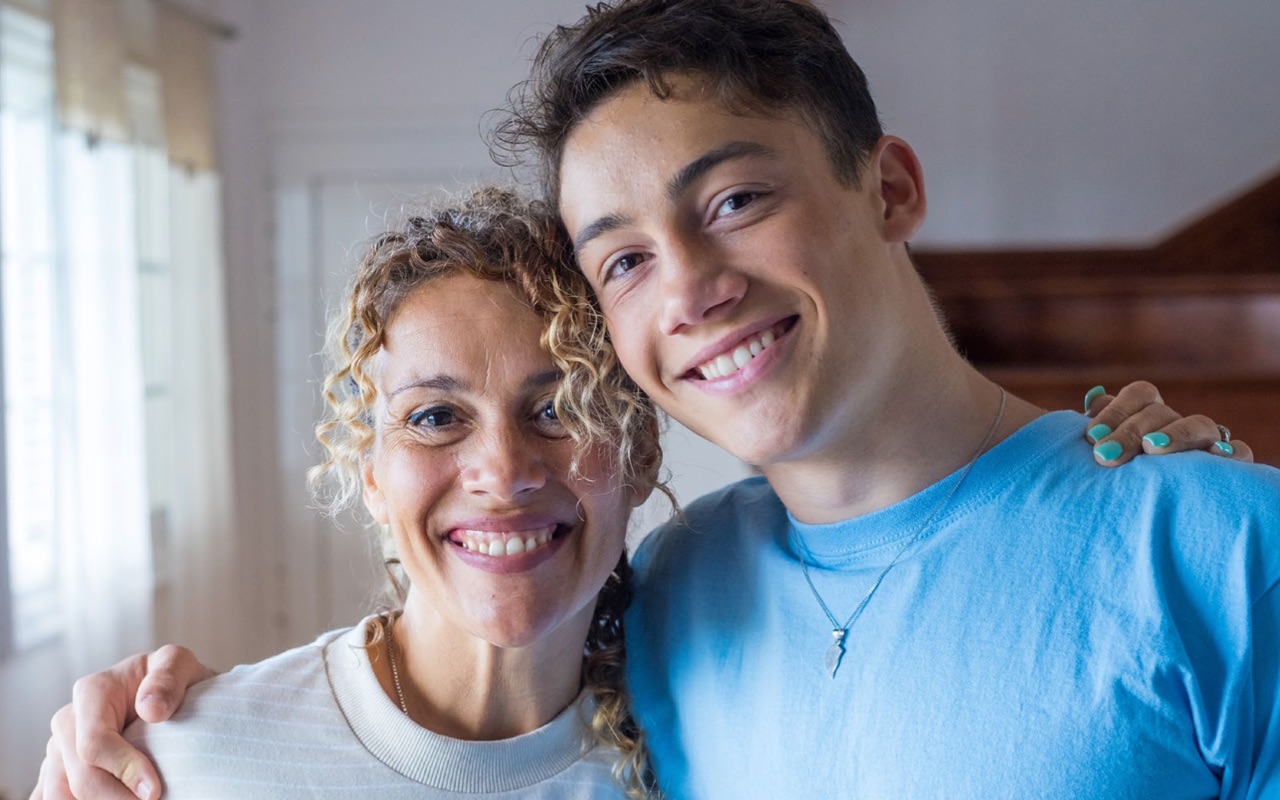 Photo of mother and son smiling at camera