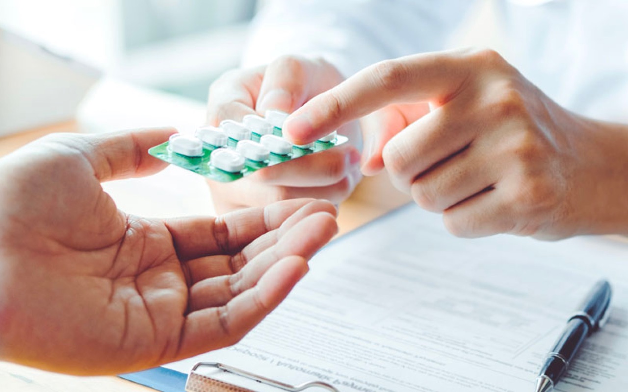 Photo of pharmacist handing medication to a patient