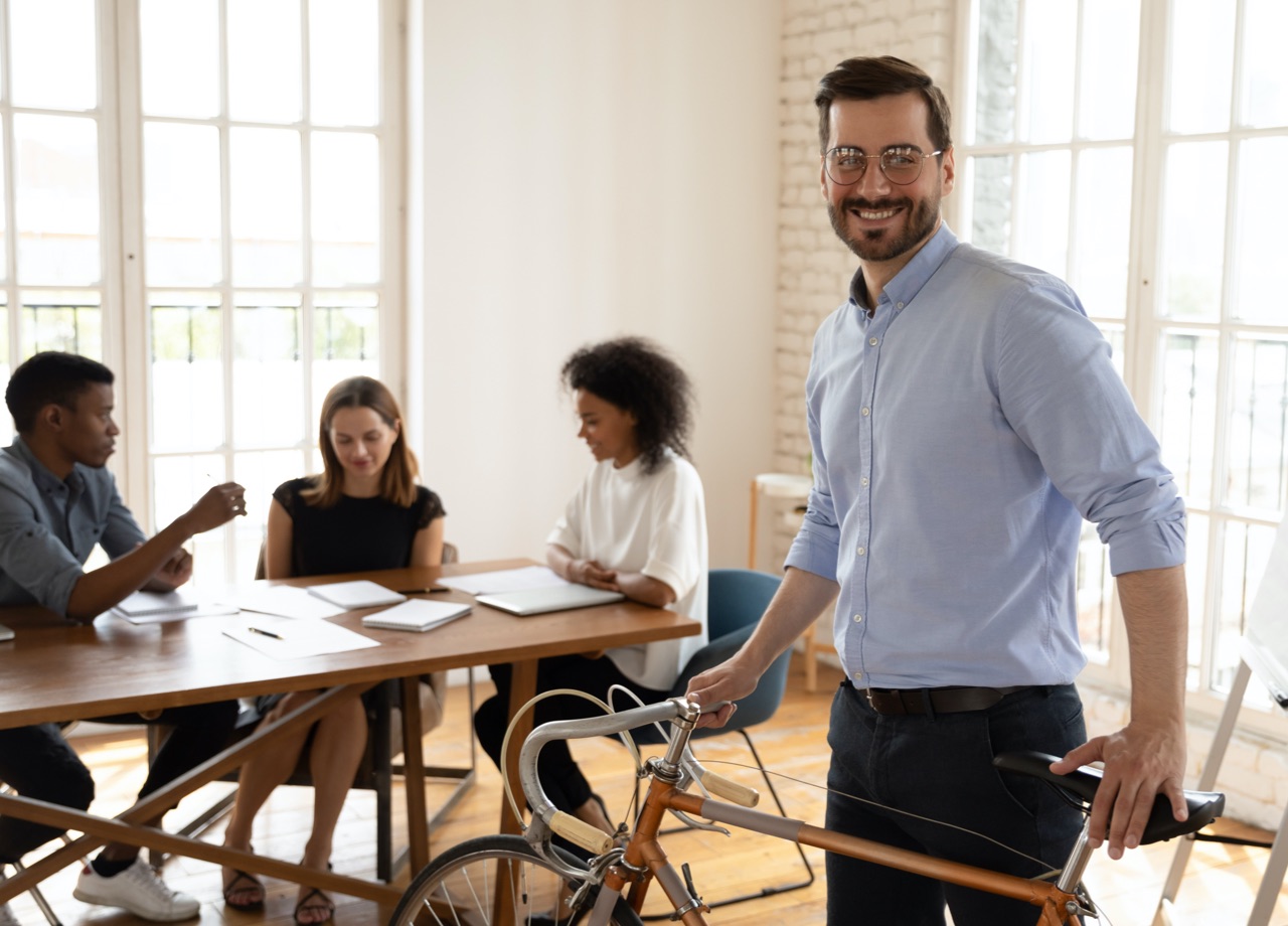 Man in office with bike looking at camera