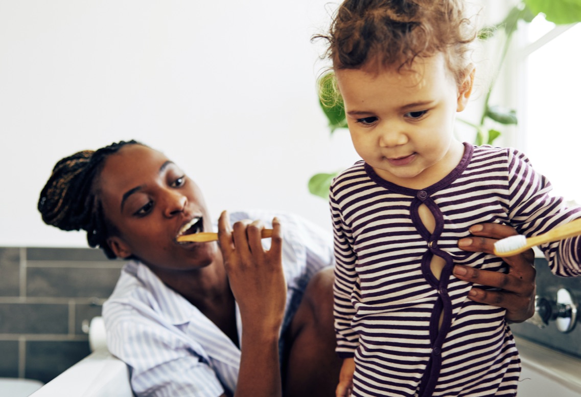 Mother brushing teeth with child