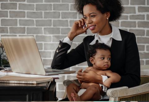 Mother working from home with infant in lap
