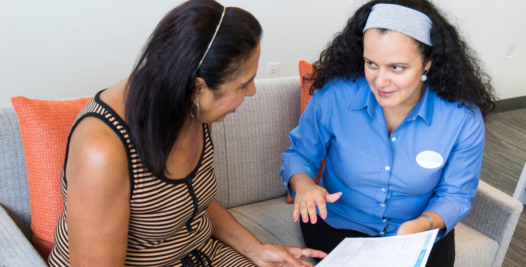 Retail associate helping woman in store