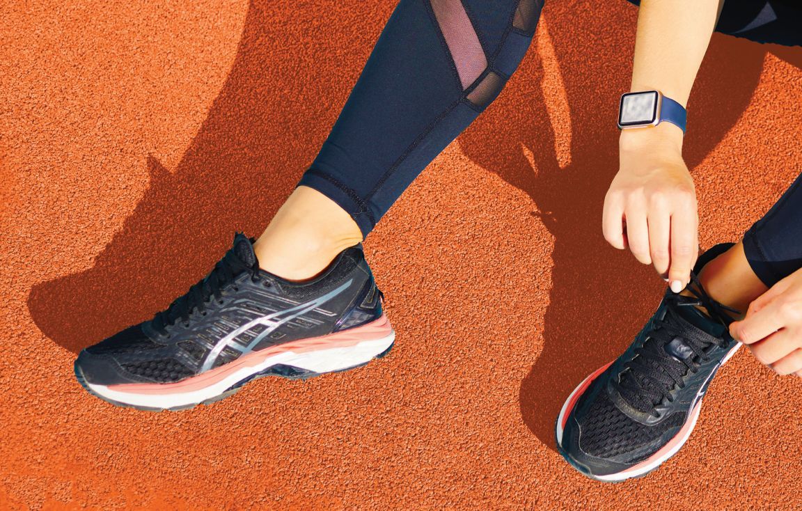 athlete tying shoe on track