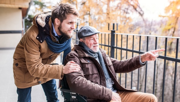 Photo of son pushing his father in wheelchair