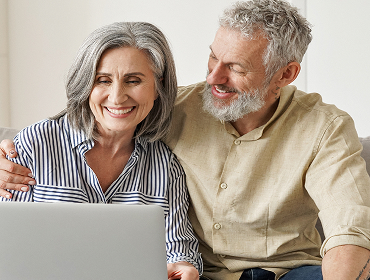 A senior couple looking at a laptop together