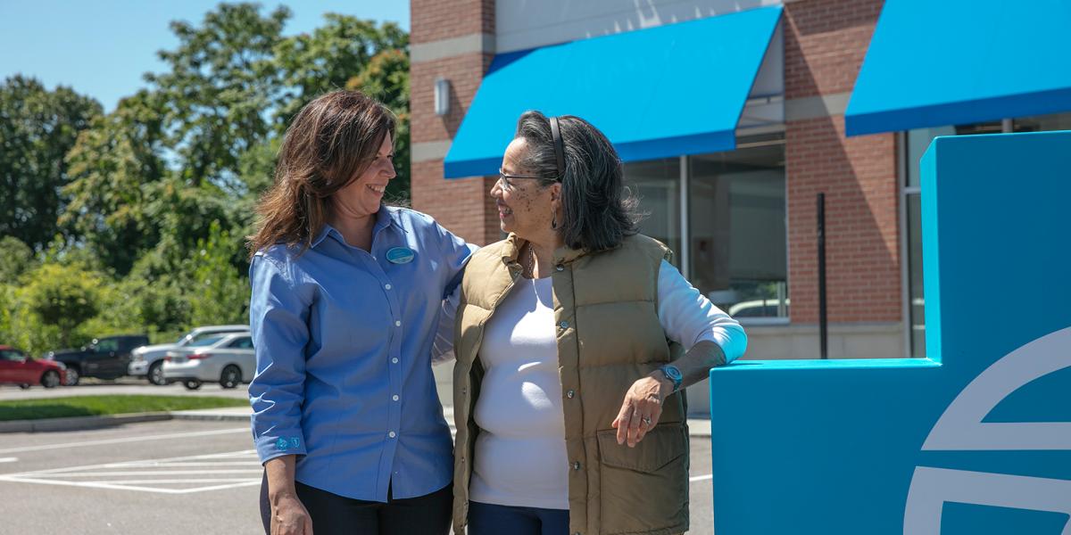 Melanie Teixeira, front desk receptionist at the East Providence Your Blue Store, talks with Muriel Jobbers, a BCBSRI customer.