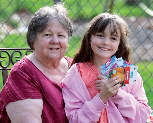 Grandmother and granddaughter looking at camera and smiling