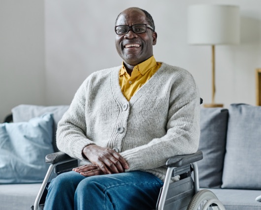 Hombre afroamericano mayor en silla de ruedas sonriendo
