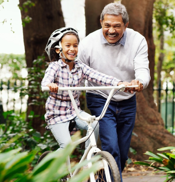 Homem sénior com neta de bicicleta